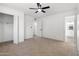 Bright bedroom featuring neutral carpet, a ceiling fan, access to a closet, and an ensuite bathroom at 13624 N 31St Ave, Phoenix, AZ 85029