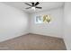 Bright bedroom featuring neutral carpet, a ceiling fan, and a window providing natural light at 13624 N 31St Ave, Phoenix, AZ 85029
