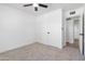 Bright bedroom featuring neutral carpet, a ceiling fan, a doorway, and base molding at 13624 N 31St Ave, Phoenix, AZ 85029