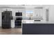 Modern kitchen featuring white cabinets, stainless steel appliances, quartz countertops, and a dark gray island at 13624 N 31St Ave, Phoenix, AZ 85029