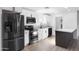 Contemporary kitchen with white cabinetry, stainless steel appliances, quartz countertops, and a dark gray island at 13624 N 31St Ave, Phoenix, AZ 85029