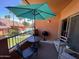 Relaxing patio with table, chairs, grill and umbrella overlooking community pool and palm trees at 14950 W Mountain View Blvd # 2210, Surprise, AZ 85374