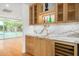 Elegant bar with marble countertop, wood cabinets, and a wine cooler, perfect for entertaining at 16227 N 63Rd Pl, Scottsdale, AZ 85254