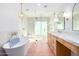 Well lit bathroom features a soaking tub, glass enclosed shower, marble counters, and wood cabinets at 16227 N 63Rd Pl, Scottsdale, AZ 85254