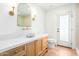 Elegant bathroom with decorative mirror, sconces, marble countertop, and wood cabinetry at 16227 N 63Rd Pl, Scottsdale, AZ 85254