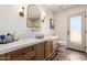 Elegant bathroom with wood cabinets, marble countertops, stylish fixtures, and an exterior door at 16227 N 63Rd Pl, Scottsdale, AZ 85254