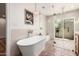 Luxurious bathroom with a freestanding tub, glass-enclosed shower, and access to an outdoor space at 16227 N 63Rd Pl, Scottsdale, AZ 85254
