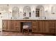 Stylish bathroom with double vanity, marble countertop, arched mirrors, and terra-cotta tile floor at 16227 N 63Rd Pl, Scottsdale, AZ 85254