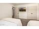 Cozy bedroom featuring grey carpet, twin beds, wall-mounted TV, and a view to the en-suite bathroom at 16227 N 63Rd Pl, Scottsdale, AZ 85254