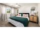 Bright bedroom featuring a large bed with a green throw blanket, side tables, and modern decor accents at 16227 N 63Rd Pl, Scottsdale, AZ 85254