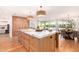 Spacious kitchen boasts a large island with marble countertop, custom cabinetry, and seamless flow to the dining and living areas at 16227 N 63Rd Pl, Scottsdale, AZ 85254