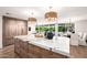 Large kitchen island with marble countertop, adjacent to the dining area and overlooking the backyard at 16227 N 63Rd Pl, Scottsdale, AZ 85254