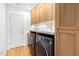 Well-lit laundry room featuring cabinetry, marble countertops, and modern washer and dryer at 16227 N 63Rd Pl, Scottsdale, AZ 85254