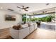 Bright living room with ceiling fan, large sectional, and an expansive view of the private backyard at 16227 N 63Rd Pl, Scottsdale, AZ 85254