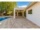 Inviting covered patio with ceiling fans, travertine flooring, and an adjacent pool for outdoor relaxation and entertaining at 16227 N 63Rd Pl, Scottsdale, AZ 85254