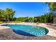 Sparkling pool surrounded by travertine tile, lush landscaping, and comfortable lounge chairs at 16227 N 63Rd Pl, Scottsdale, AZ 85254