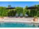 Inviting pool area with lounge chairs, water features, privacy hedges, and mature landscaping at 16227 N 63Rd Pl, Scottsdale, AZ 85254