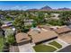 Stunning aerial view of a home with a private pool, lush greenery, mountain views, and a well-maintained lawn at 1640 E Solano Dr, Phoenix, AZ 85016