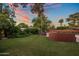 Spacious backyard with lush lawn, mature trees, and ambient string lights, perfect for outdoor entertaining at 1640 E Solano Dr, Phoenix, AZ 85016
