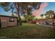 Lush backyard featuring green grass, mature trees, and outdoor seating, perfect for enjoying nature at 1640 E Solano Dr, Phoenix, AZ 85016
