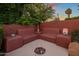 Outdoor living area with built-in seating, a fire pit, and mature trees, creating a cozy and inviting space at 1640 E Solano Dr, Phoenix, AZ 85016