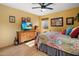 Bedroom featuring a wood dresser with a TV, colorful bedspread, and neutral decor at 1640 E Solano Dr, Phoenix, AZ 85016