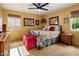 Bright bedroom with a patterned bedspread, a red bench, and complementary artwork at 1640 E Solano Dr, Phoenix, AZ 85016