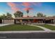 Charming single-story home with well-manicured lawn, welcoming walkway and palm tree under a colorful sunset sky at 1640 E Solano Dr, Phoenix, AZ 85016