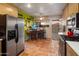 Bright kitchen featuring stainless steel appliances, wooden breakfast bar, and terracotta tile flooring at 1640 E Solano Dr, Phoenix, AZ 85016
