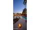 Sparkling pool and hot tub surrounded by lush landscaping and string lights, creating a tranquil backyard oasis at 1640 E Solano Dr, Phoenix, AZ 85016