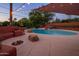 Serene backyard boasts a refreshing pool, fire pit, and cozy built-in seating surrounded by landscaping at 1640 E Solano Dr, Phoenix, AZ 85016