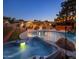 Backyard oasis featuring a sparkling pool and hot tub with a bar, seating, and string lights, perfect for relaxing evenings at 1640 E Solano Dr, Phoenix, AZ 85016
