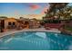 Stunning backyard features a sparkling pool, bar area, and seating beneath string lights at dusk at 1640 E Solano Dr, Phoenix, AZ 85016