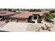 Aerial view of a beautiful home showcasing a three-car garage, desert landscape, and tile roof at 17406 N Escalante Ln, Surprise, AZ 85374