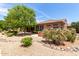 Charming backyard with lush plants, gravel landscaping, and partial view of golf course at 17406 N Escalante Ln, Surprise, AZ 85374