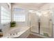 Bright bathroom with a glass-enclosed shower and a soaking tub at 17406 N Escalante Ln, Surprise, AZ 85374
