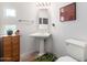 Traditional bathroom featuring a pedestal sink, decorative art and a light wood cabinet at 17406 N Escalante Ln, Surprise, AZ 85374