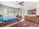 Sunlit bedroom with a ceiling fan, desert views, and an exterior door at 17406 N Escalante Ln, Surprise, AZ 85374