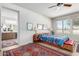 Bright bedroom with a ceiling fan, large windows, and an en suite bathroom view at 17406 N Escalante Ln, Surprise, AZ 85374