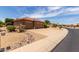 Charming home exterior with a three-car garage, desert landscaping, and mature trees at 17406 N Escalante Ln, Surprise, AZ 85374