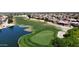 Aerial view of the manicured golf course with a pond, alongside homes in a community at 17406 N Escalante Ln, Surprise, AZ 85374