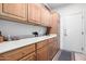 Convenient laundry room featuring wood cabinets, spacious countertop, and stylish rug at 17406 N Escalante Ln, Surprise, AZ 85374