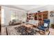 Bright living room featuring large windows, bookshelves, and comfortable seating at 17406 N Escalante Ln, Surprise, AZ 85374