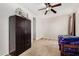Carpeted bedroom featuring a ceiling fan, closet, and dark wood furniture at 1876 E Azalea Ct, Gilbert, AZ 85298