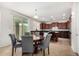 Bright dining area with a round wooden table, upholstered chairs, and sliding glass doors to the backyard at 1876 E Azalea Ct, Gilbert, AZ 85298