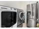 This laundry room comes equipped with modern washer and dryer and a stainless steel fridge at 1876 E Azalea Ct, Gilbert, AZ 85298