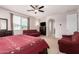 This spacious main bedroom has a ceiling fan, dresser, with a couch, and entry to the bathroom at 1876 E Azalea Ct, Gilbert, AZ 85298