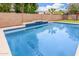 Relax in this sparkling blue swimming pool with a decorative tile and a surrounding patio at 1876 E Azalea Ct, Gilbert, AZ 85298