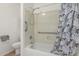 Bathroom featuring a toilet, bathtub-shower combo with a patterned curtain, and grab bars at 20424 N 96Th Ln, Peoria, AZ 85382