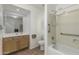Bathroom featuring a wooden vanity, toilet, and bathtub-shower combo with accessibility bars at 20424 N 96Th Ln, Peoria, AZ 85382
